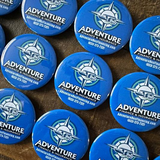 Multiple blue buttons with Adventure Finance & Insurance logo on a textured surface.