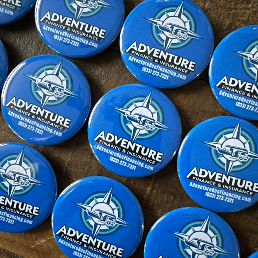 Multiple blue buttons with Adventure Finance & Insurance logo on a textured surface.
